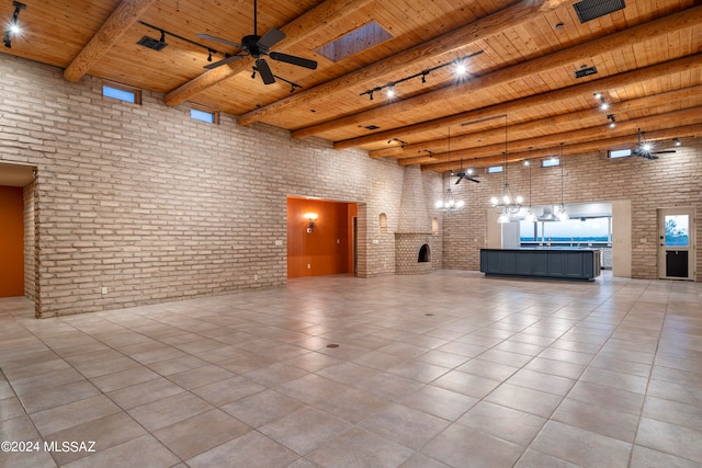 interior space featuring beam ceiling, ceiling fan, a towering ceiling, and wooden ceiling