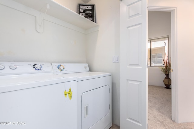 laundry room with light colored carpet and washer and dryer