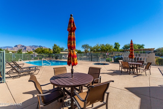 view of swimming pool with a mountain view and a patio area