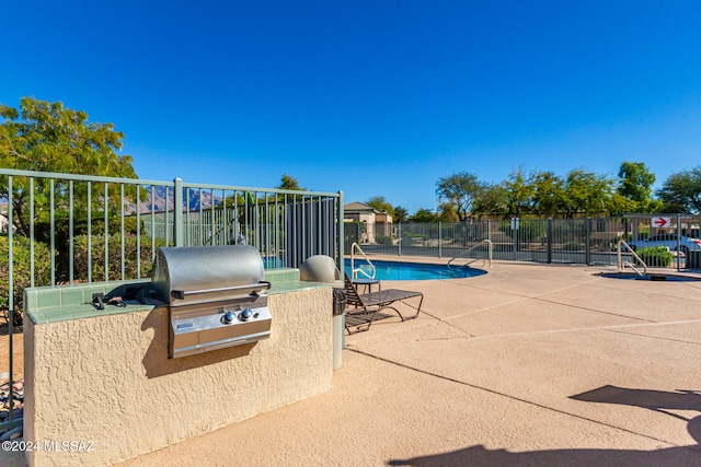 view of patio / terrace with a community pool and grilling area