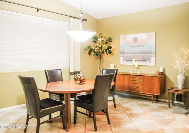 dining room featuring vaulted ceiling and light tile patterned floors