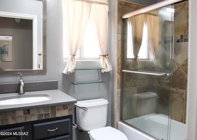 full bathroom with toilet, enclosed tub / shower combo, and vanity