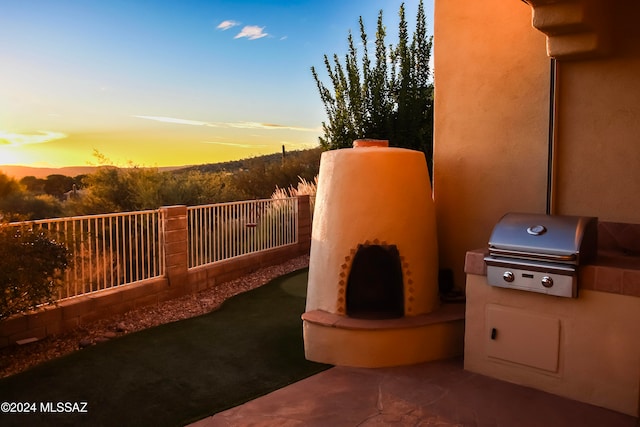 patio terrace at dusk featuring grilling area