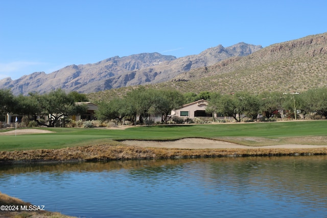 exterior space featuring a water and mountain view and a lawn