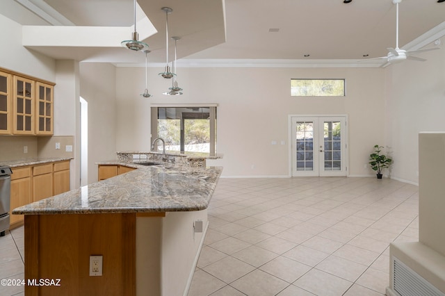 kitchen featuring a high ceiling, ceiling fan, a healthy amount of sunlight, and sink