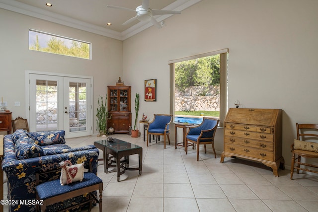 tiled living room with ceiling fan, a healthy amount of sunlight, a high ceiling, and french doors