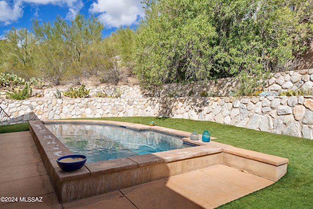 view of swimming pool with a yard