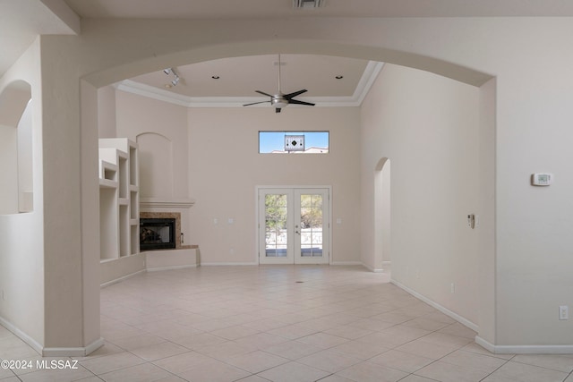 unfurnished living room with ceiling fan, french doors, light tile patterned floors, and ornamental molding