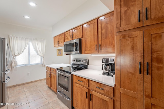 kitchen with light tile patterned flooring, recessed lighting, light countertops, brown cabinets, and appliances with stainless steel finishes