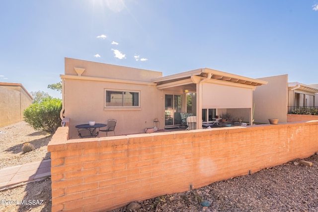 back of house with fence and stucco siding