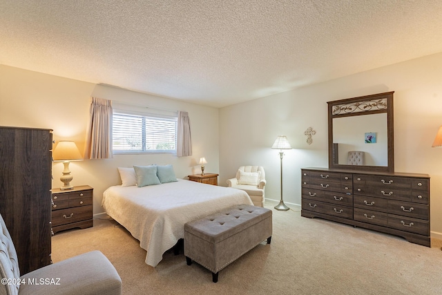 bedroom with baseboards, a textured ceiling, and light carpet