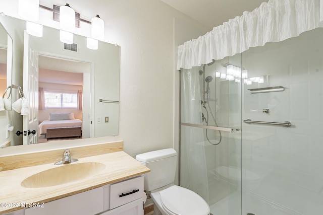 bathroom with vanity, a shower stall, toilet, and visible vents