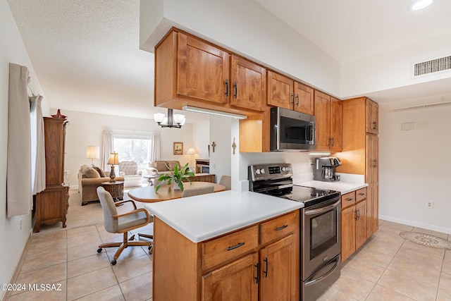 kitchen featuring light countertops, open floor plan, appliances with stainless steel finishes, and light tile patterned floors