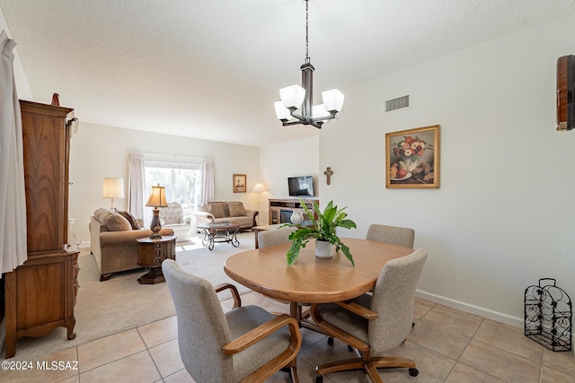 dining room featuring light tile patterned floors, baseboards, a notable chandelier, and visible vents