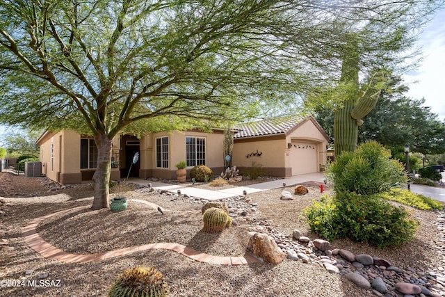 view of front of home with central air condition unit and a garage