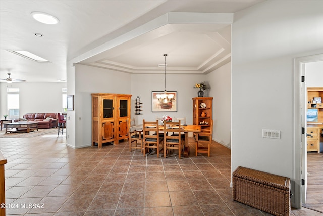 dining room with ceiling fan, tile patterned flooring, and a raised ceiling