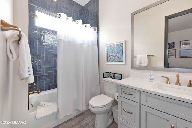 full bathroom featuring shower / bath combo, wood-type flooring, vanity, and toilet