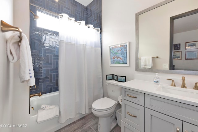 full bathroom featuring shower / bath combo with shower curtain, wood-type flooring, vanity, and toilet