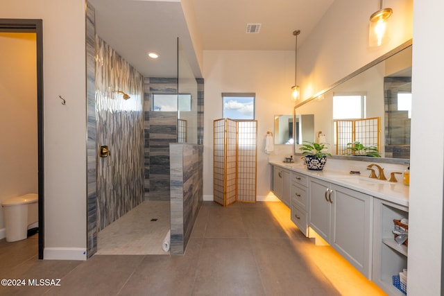 bathroom with tiled shower, vanity, and tile patterned floors