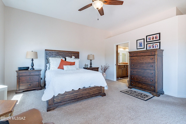 carpeted bedroom with ensuite bathroom and ceiling fan