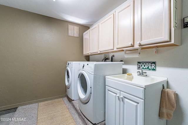 clothes washing area featuring cabinets, washer and dryer, and sink