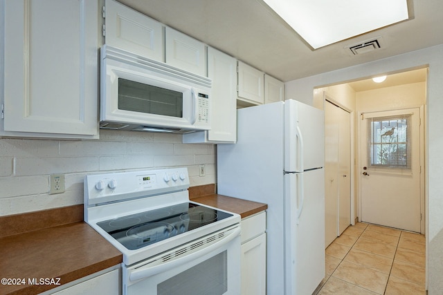 kitchen featuring backsplash, white cabinetry, white appliances, and light tile patterned flooring