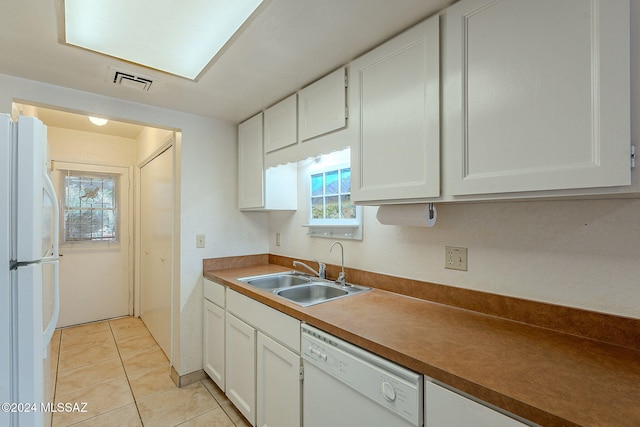 kitchen with white appliances, light tile patterned floors, sink, and white cabinets