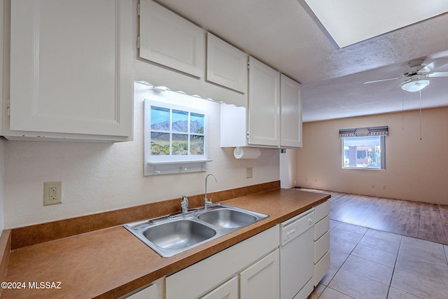 kitchen featuring light hardwood / wood-style floors, dishwasher, a healthy amount of sunlight, and white cabinetry