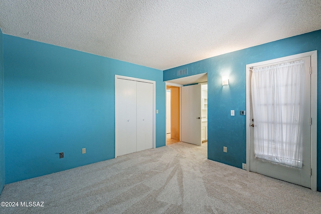 unfurnished bedroom with a closet, a textured ceiling, and light colored carpet