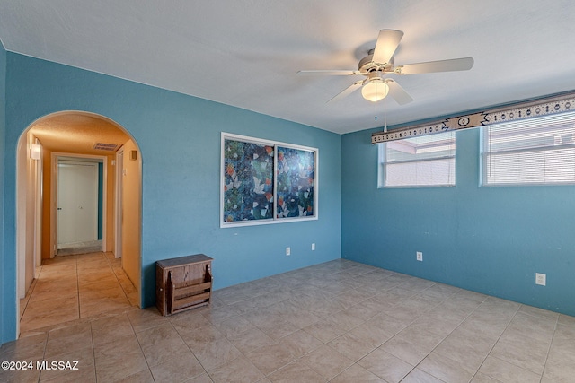 tiled empty room featuring ceiling fan