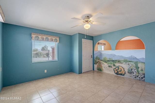 spare room featuring ceiling fan, a mountain view, a wealth of natural light, and light tile patterned floors