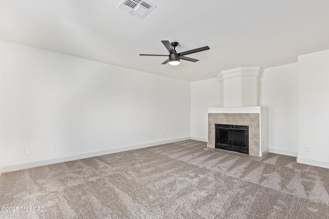 unfurnished living room with a fireplace, light colored carpet, and ceiling fan