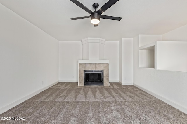 unfurnished living room with ceiling fan, carpet, and a fireplace