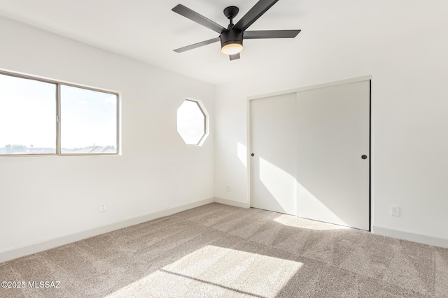 unfurnished bedroom featuring carpet floors, ceiling fan, and a closet