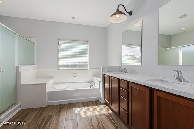 bathroom featuring shower with separate bathtub, vanity, hardwood / wood-style flooring, and a wealth of natural light