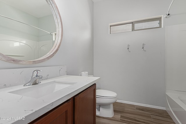 full bathroom with shower / bath combination, vanity, wood-type flooring, and toilet