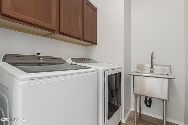 washroom with hardwood / wood-style flooring, cabinets, separate washer and dryer, and sink