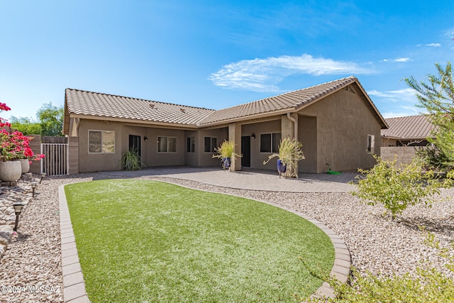 rear view of house with a yard and a patio