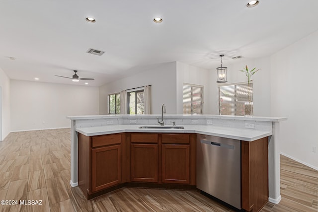 kitchen with dishwasher, light wood-type flooring, sink, and an island with sink