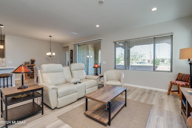 living room with light wood-type flooring and an inviting chandelier