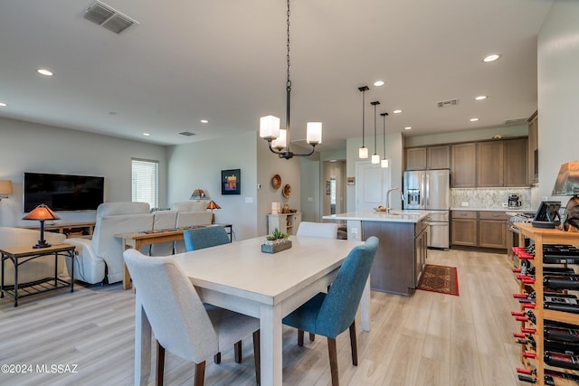 dining area with a chandelier and light hardwood / wood-style flooring