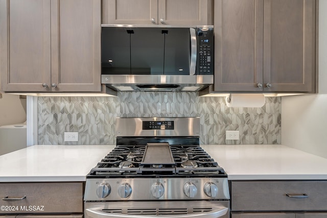 kitchen featuring gray cabinets, appliances with stainless steel finishes, and tasteful backsplash