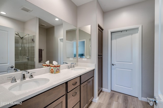 bathroom featuring a shower with door, vanity, and hardwood / wood-style flooring