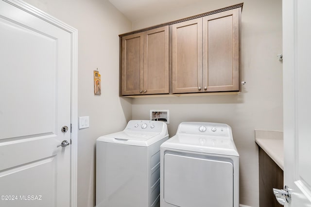 washroom featuring cabinets and washing machine and dryer