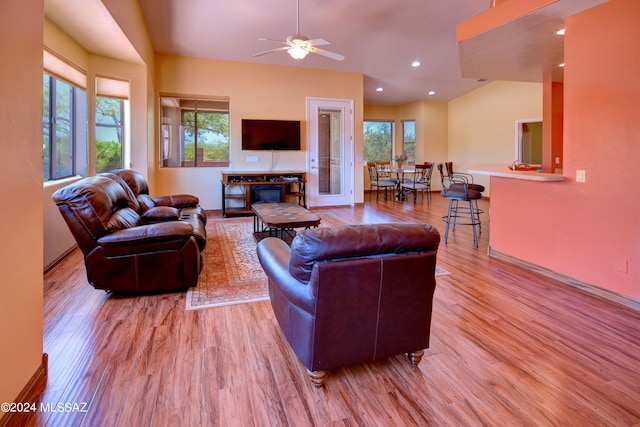 living room with ceiling fan, a healthy amount of sunlight, and light wood-type flooring