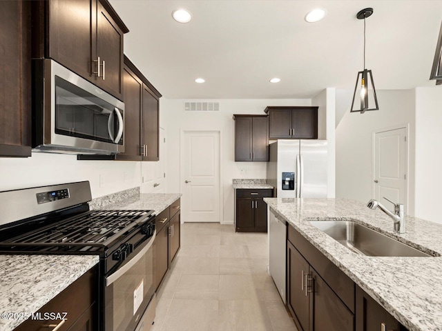 6951 W Star Garden Way, Tucson, AZ 85757 - kitchen with stainless steel appliances, a sink, dark brown cabinets, light stone counters, and recessed lighting