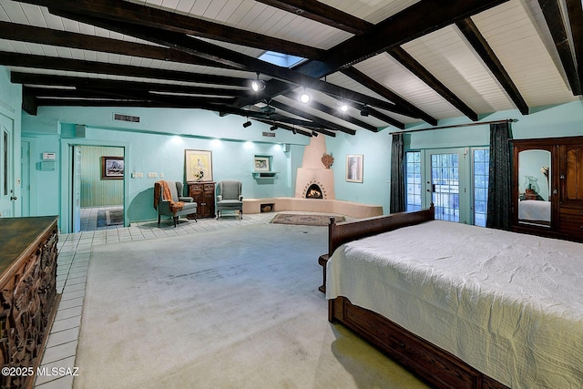 carpeted bedroom with french doors, a large fireplace, and vaulted ceiling with beams