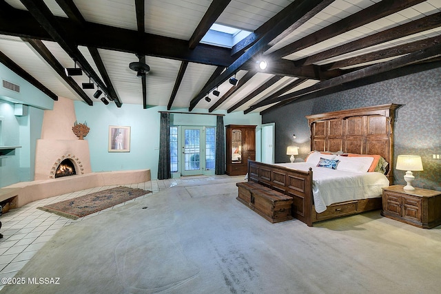 bedroom featuring a fireplace and vaulted ceiling with skylight