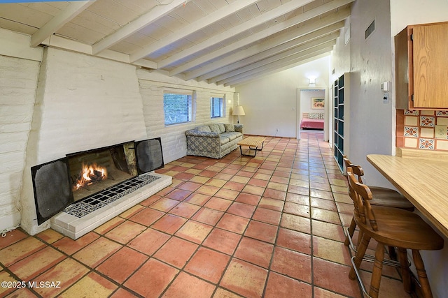 living room with light tile patterned flooring, vaulted ceiling with beams, a fireplace, and wood ceiling