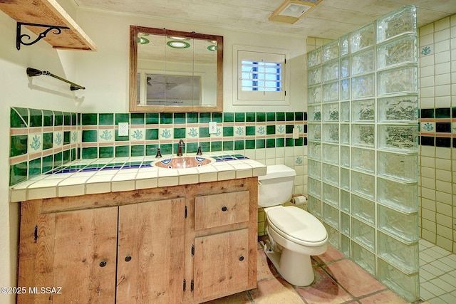 bathroom featuring a shower, tile patterned flooring, ornamental molding, vanity, and toilet